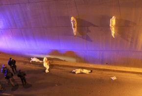 The wrapped bodies of two dead people hang from an overpass as three more dead bodies lie on the ground in Saltillo, Mexico, March 8, 2013. Reuters.